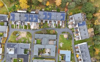 Fågelvy ovanför ett radhusområde med solceller på papptaket.